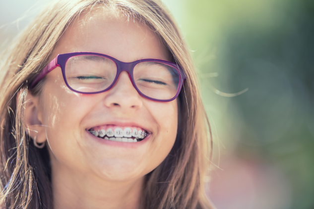Bambina sorridente con un sorriso sano.