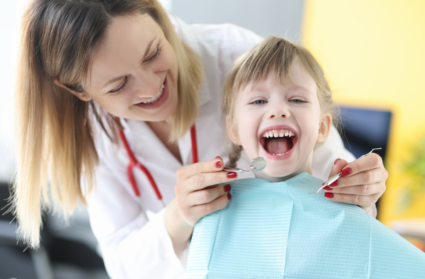 Bimbo sorridente durante visita dal dentista pediatrico.