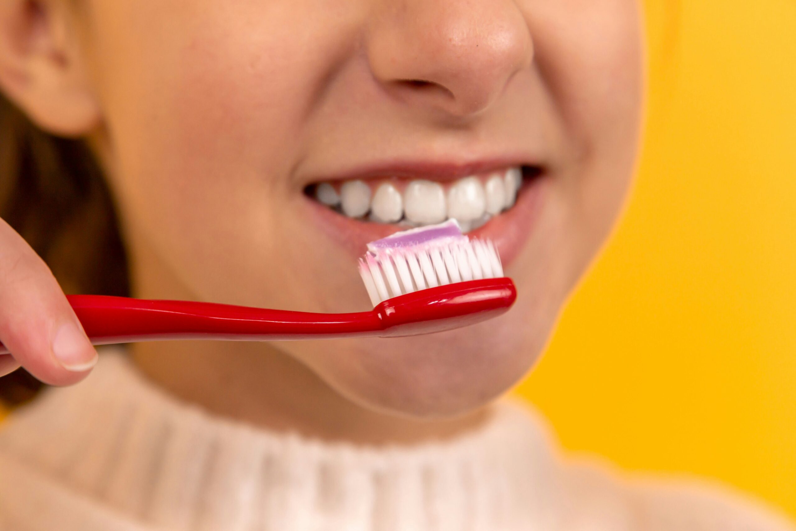 Giovane radazza che lava i denti: importanza dell'igiene orale